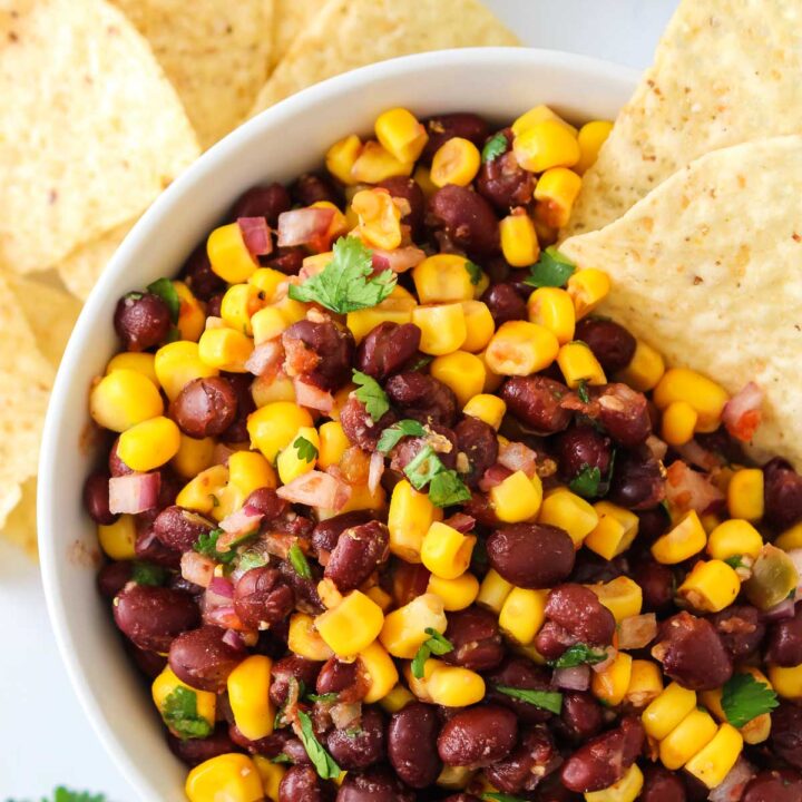 Bowl of black bean and corn salad with tortilla chips for dipping.