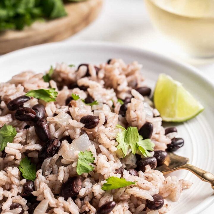 Close up of black beans and rice on plate with lime.