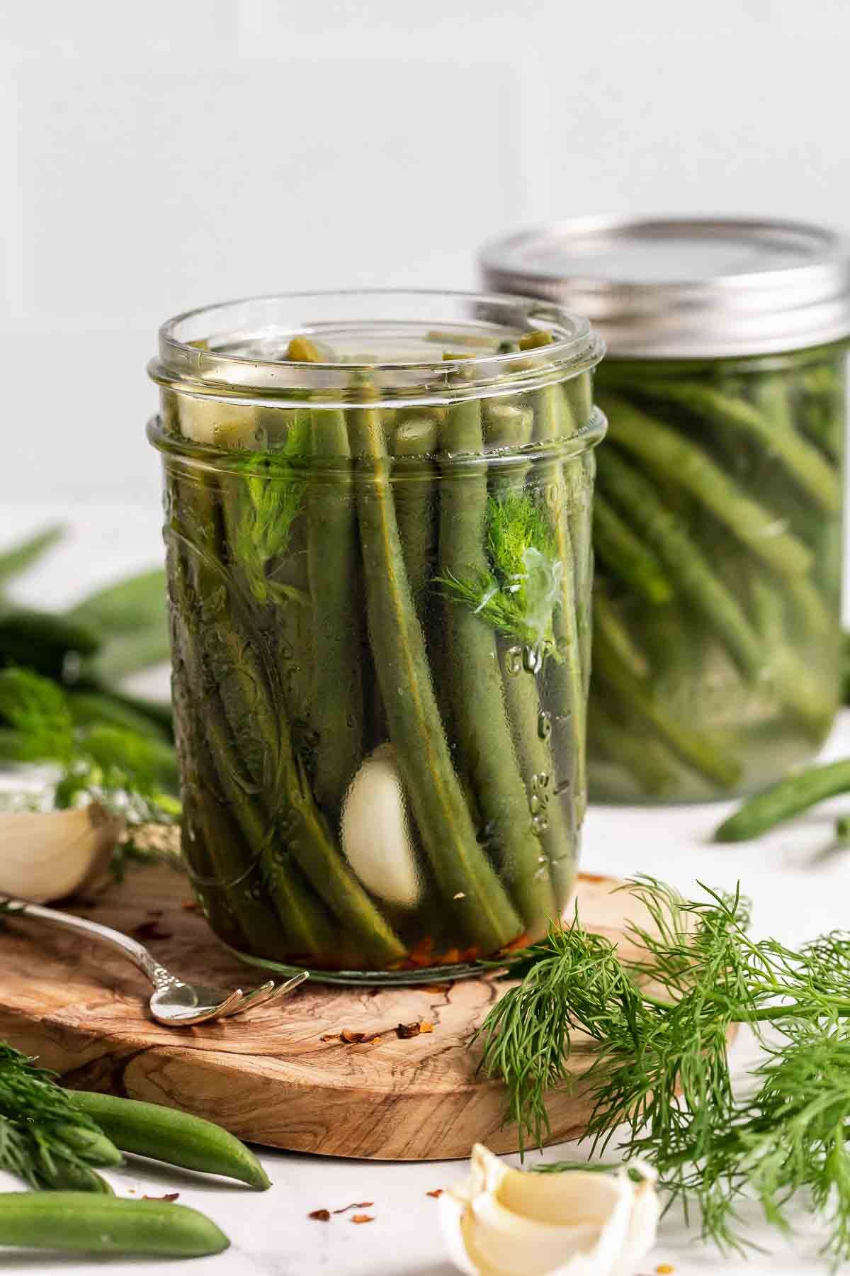 Two glass jars of pickled green beans.
