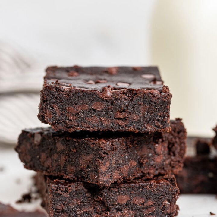 Stack of black bean brownies on white table.