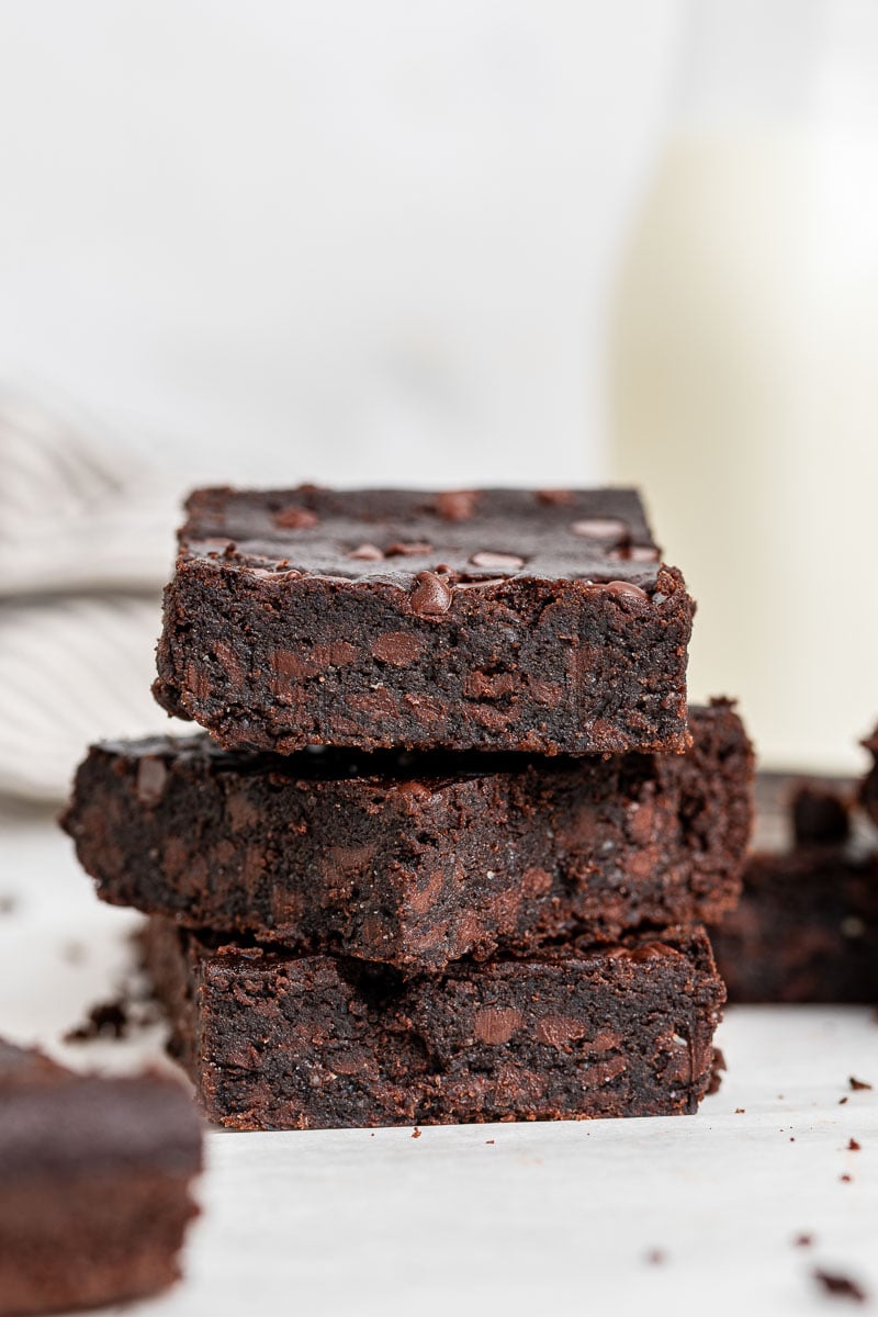 Stack of black bean brownies on white table.