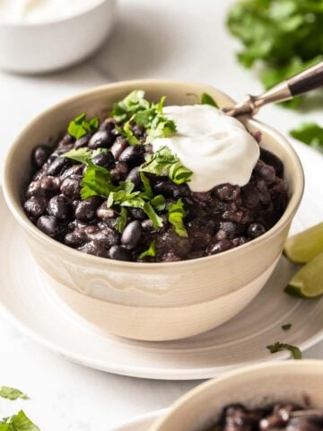 Black bean soup garnished with sour cream and cilantro.