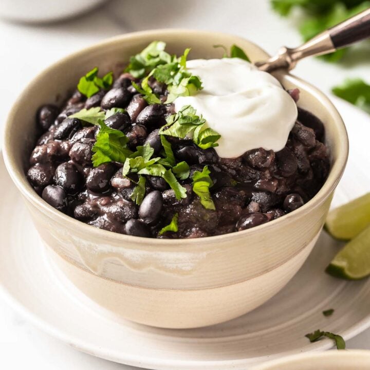 Black bean soup garnished with sour cream and cilantro.