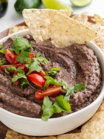 Black bean dip in bowl with tortilla chips.