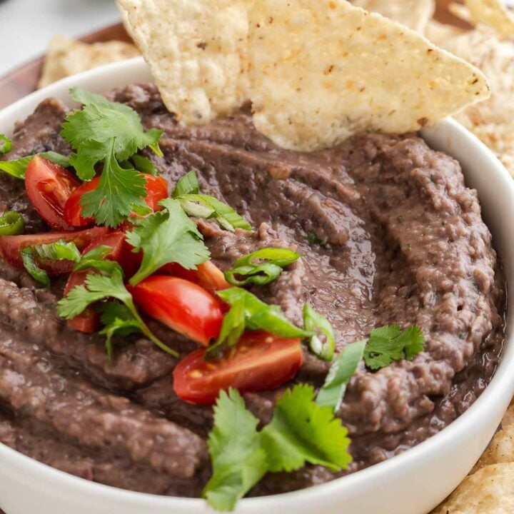 Black bean dip in bowl with tortilla chips.