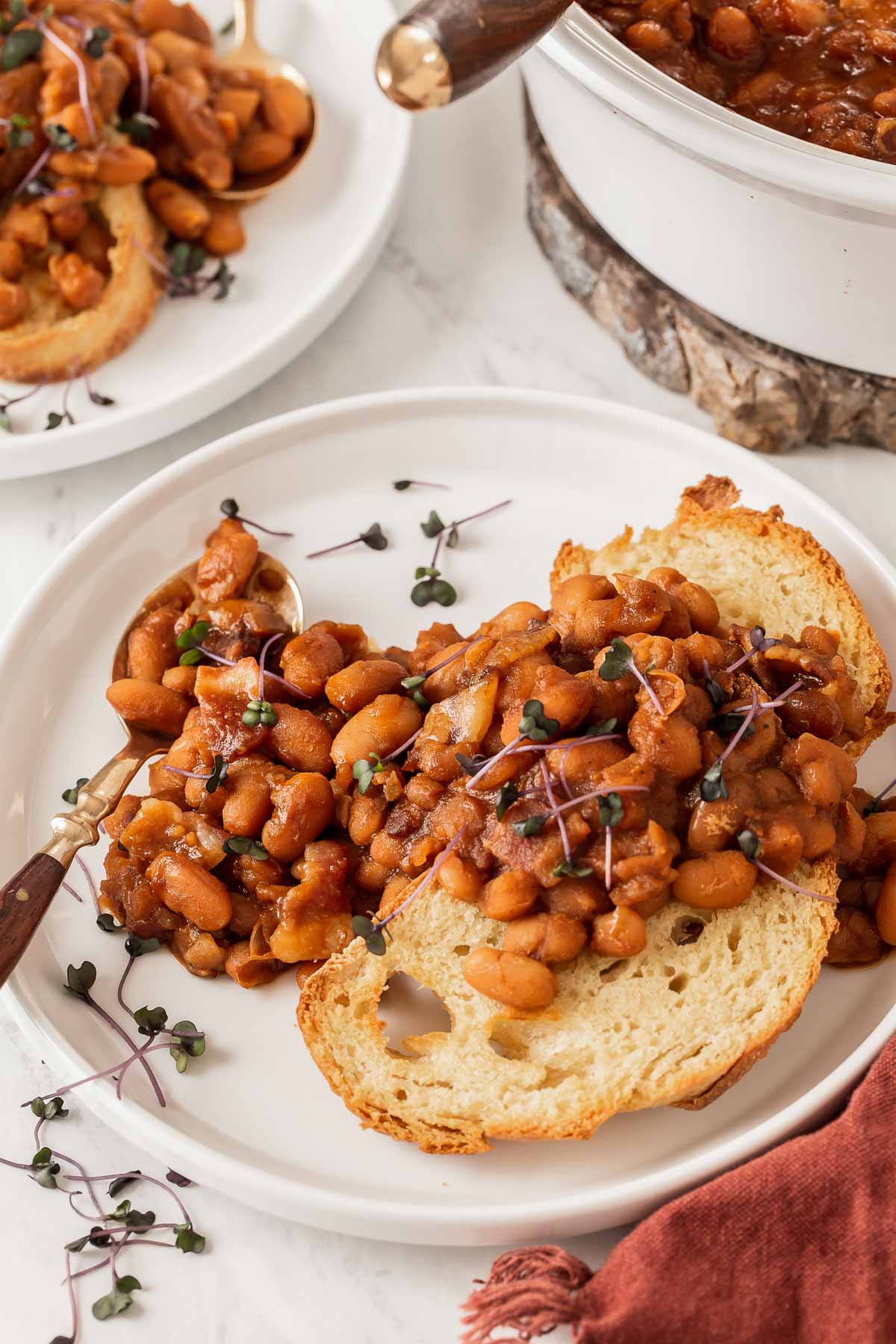 Boston baked beans scooped and served over toast with micro greens.