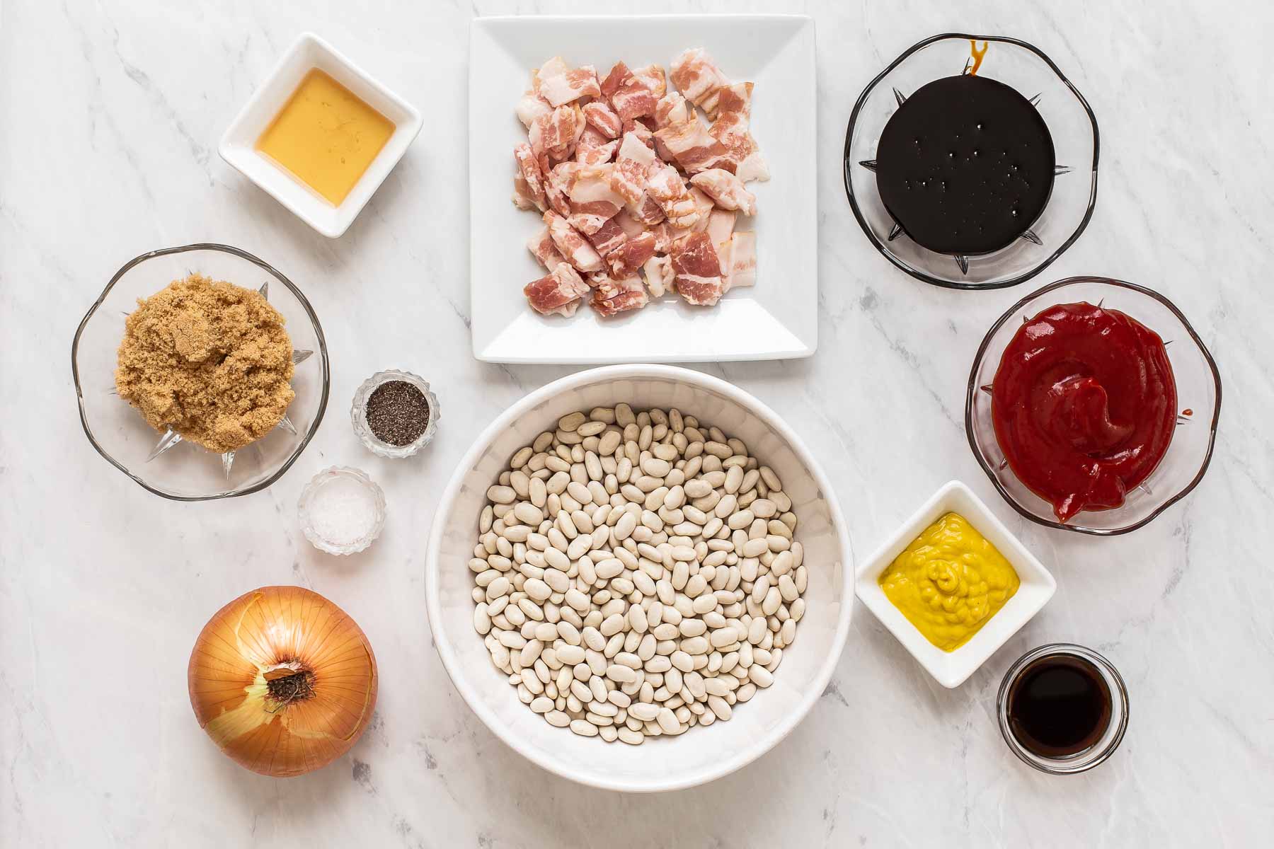 Ingredients for Boston Baked beans on table in small bowls.