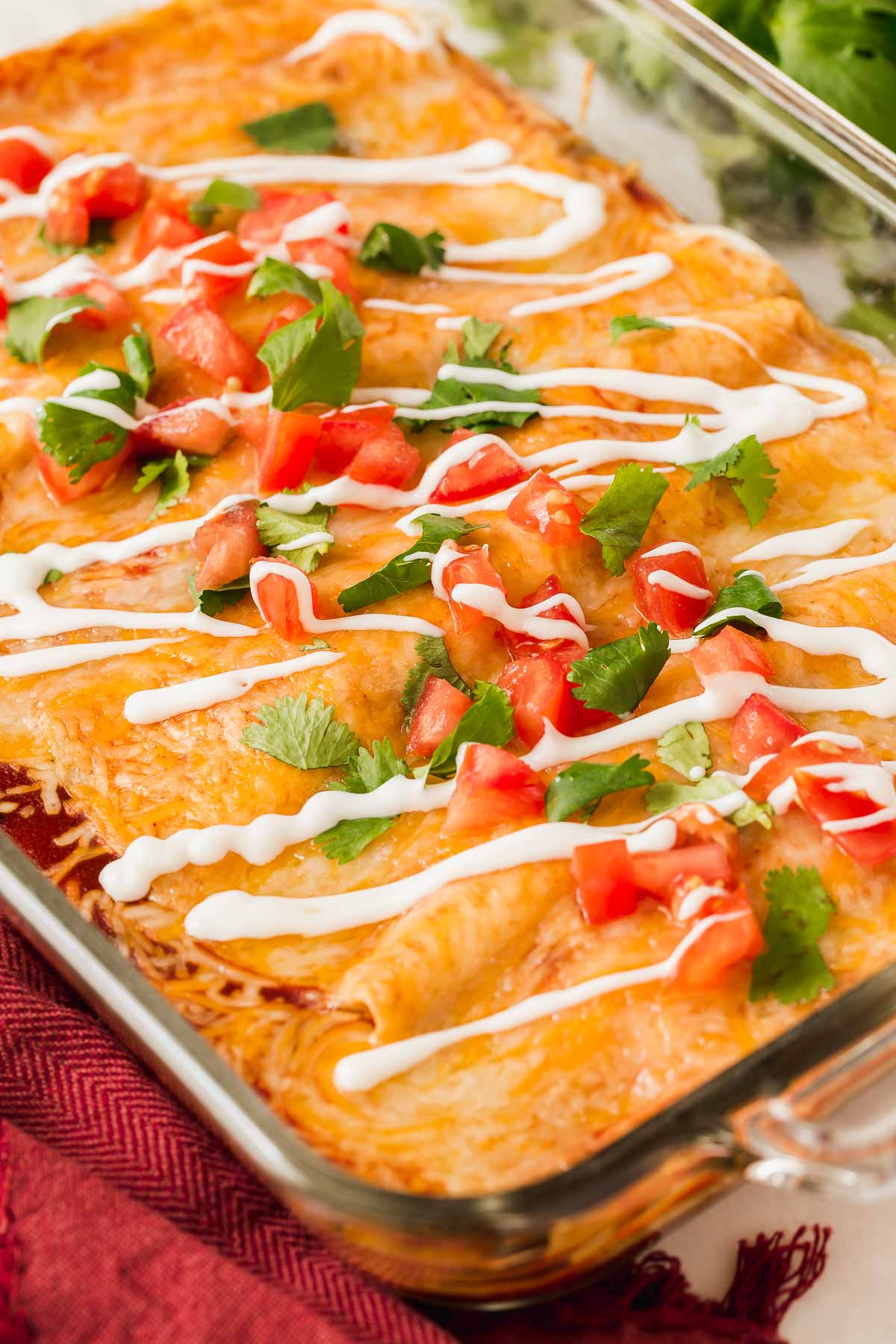 Pan of lentil enchiladas topped with pico and sour cream.