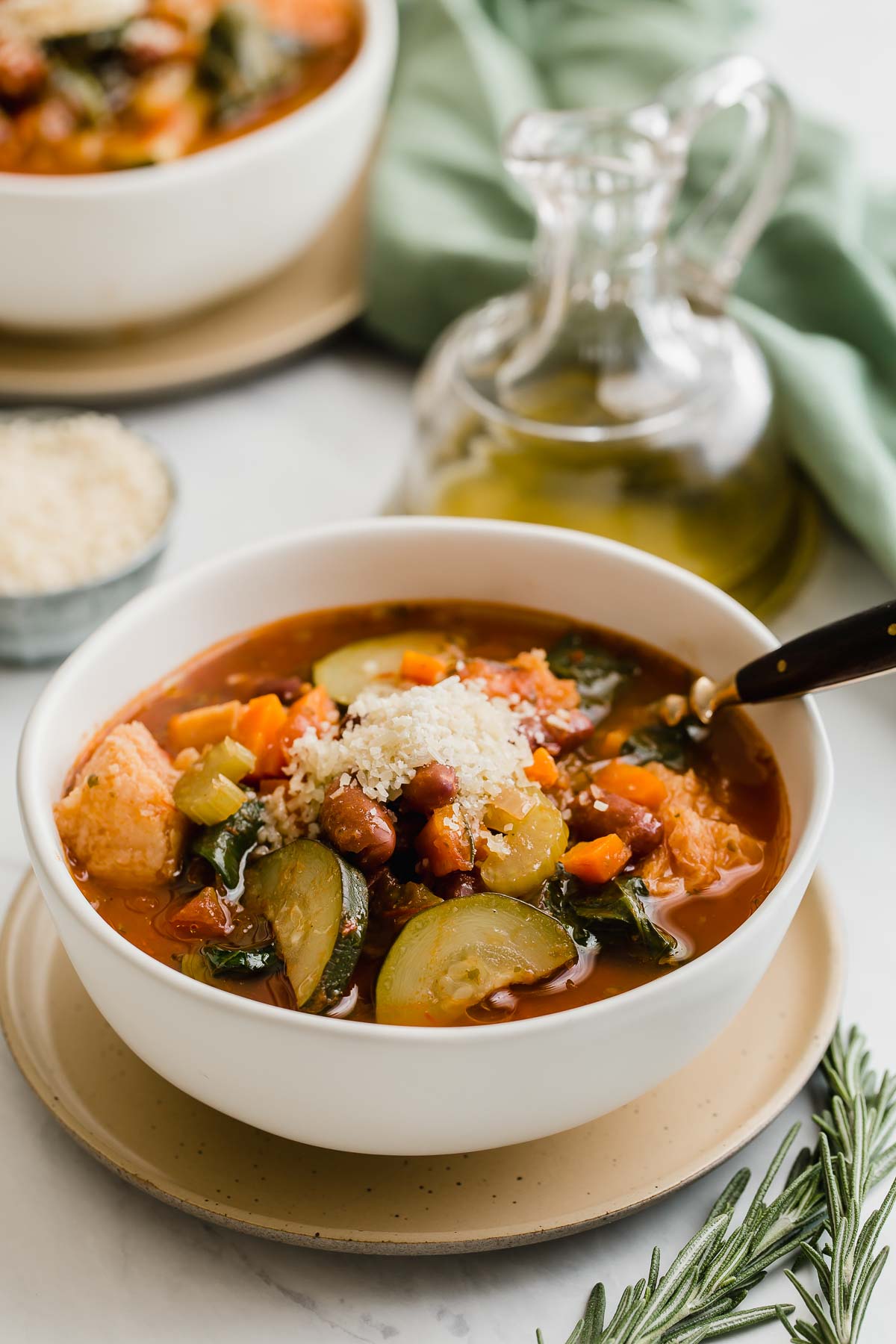 Two bowls of ribollita with serving spoons.