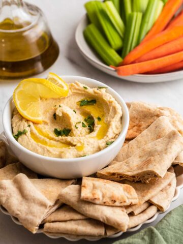 Hummus without garlic in a bowl with pita bread.