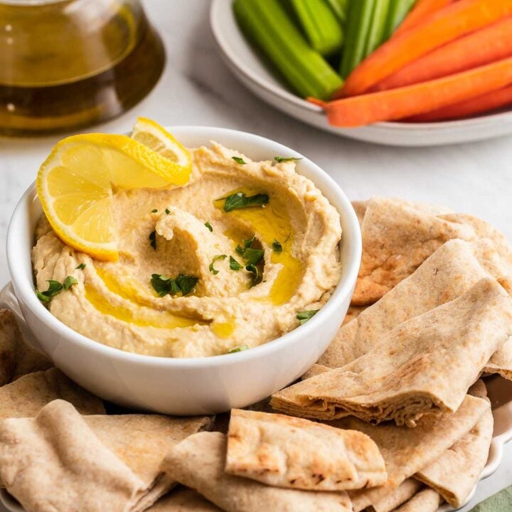 Hummus without garlic in a bowl with pita bread.