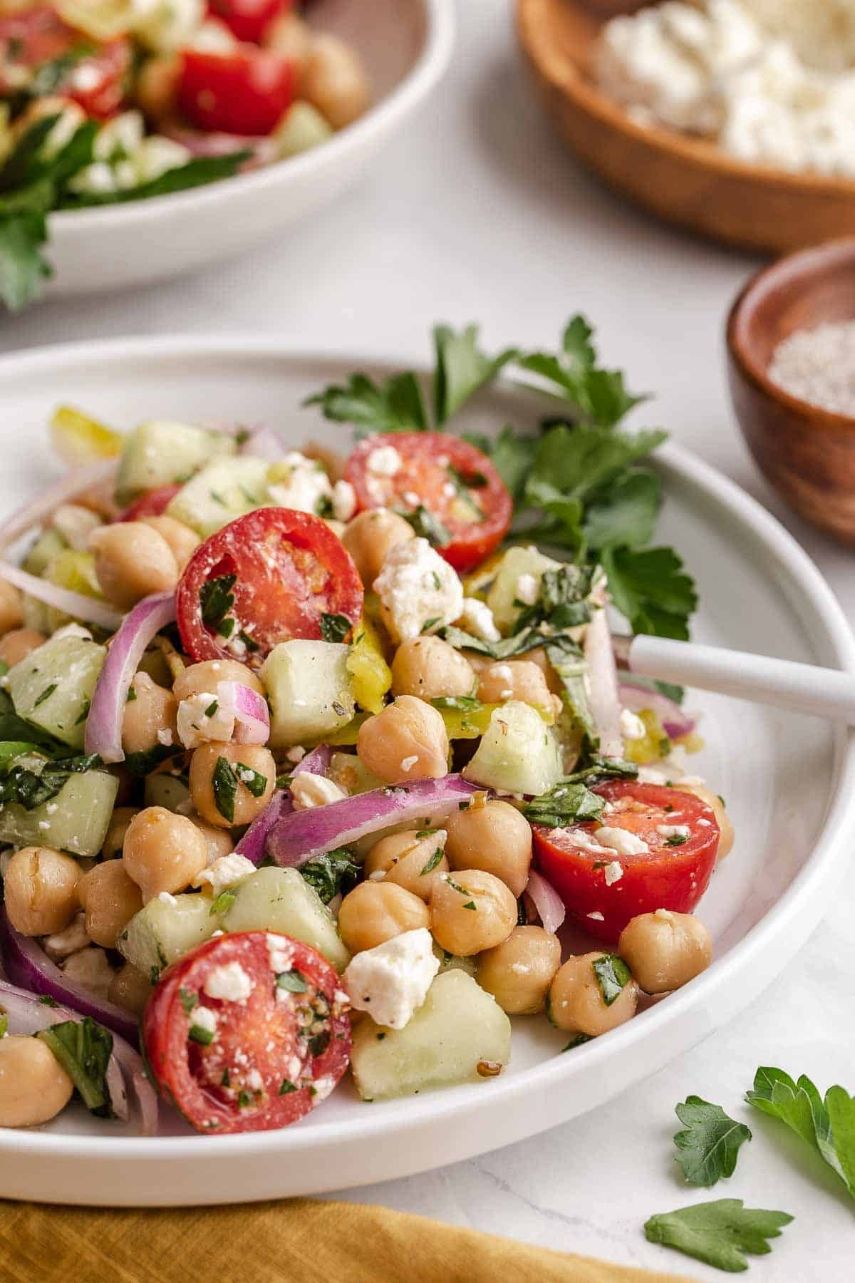 Mediterranean Chickpea Salad on white plate with parsley.