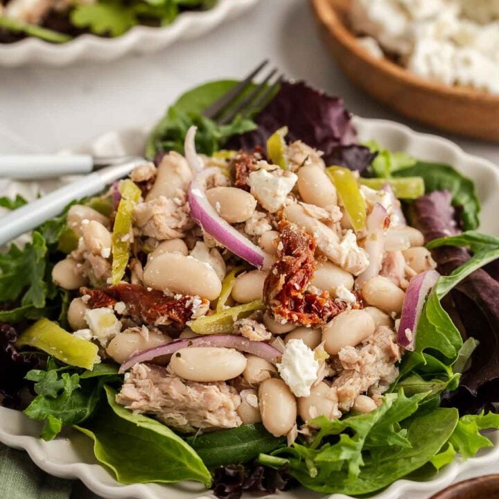 White bean tuna salad with vegetables on salad greens.