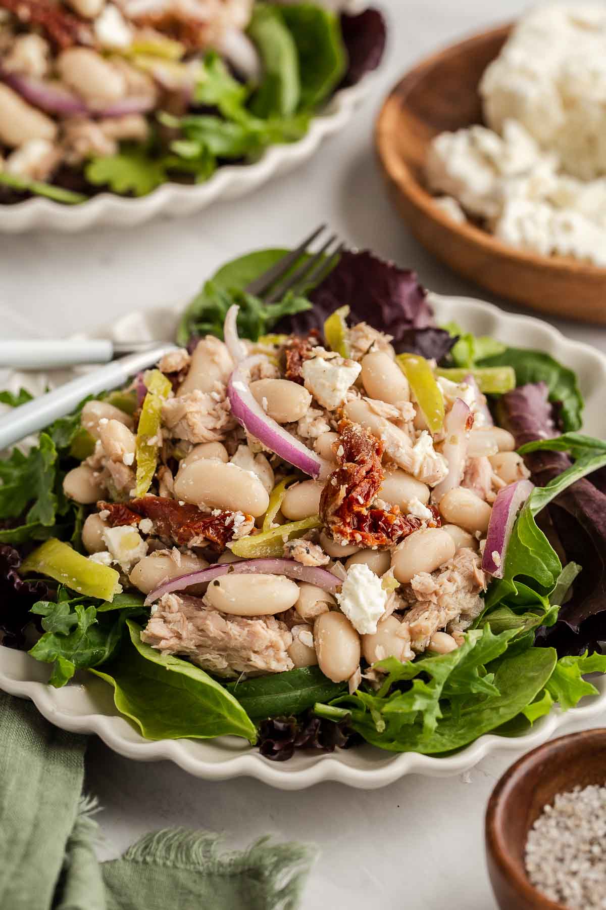 White bean tuna salad with vegetables on salad greens.