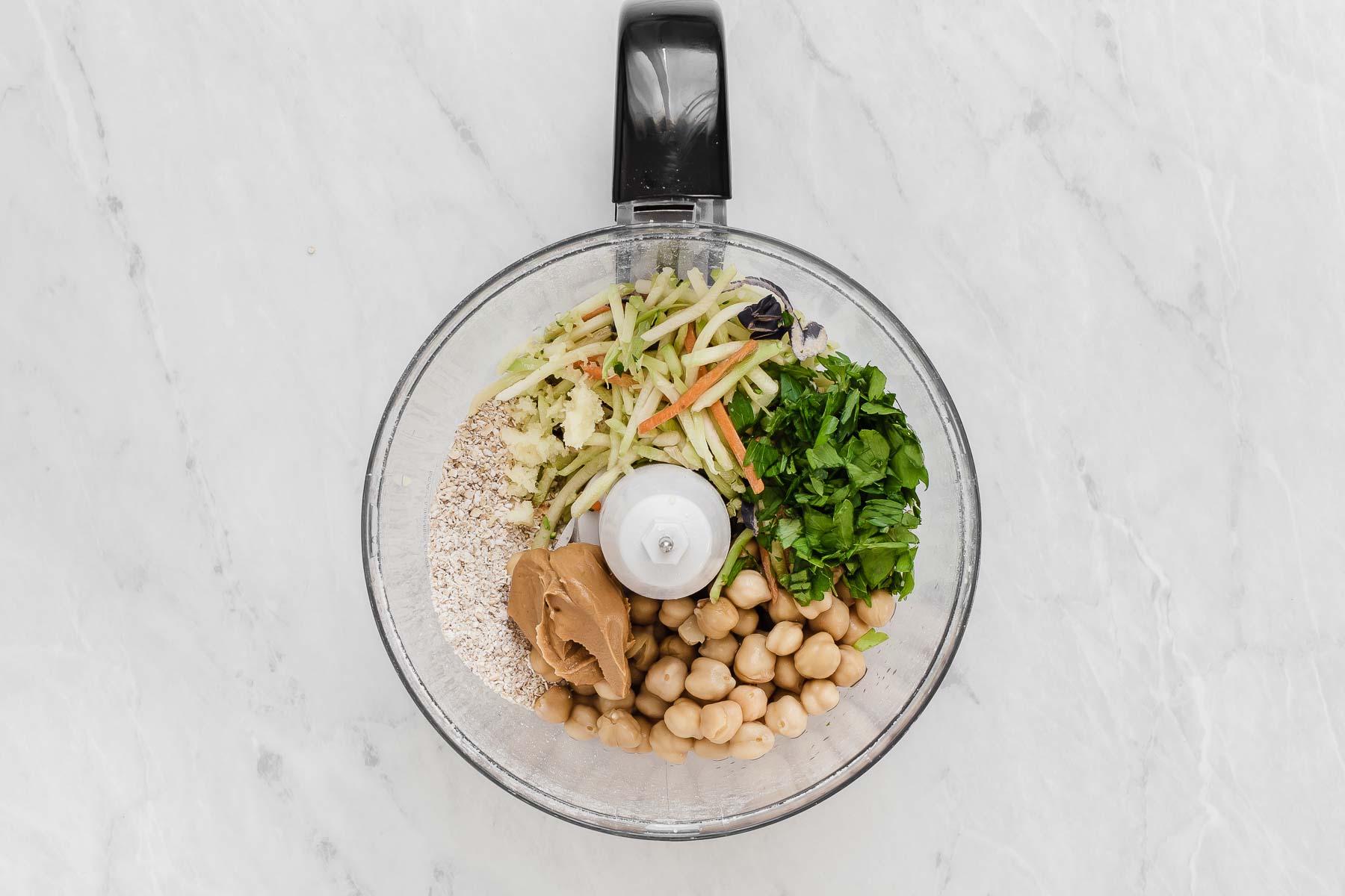 Chickpeas, cilantro, peanut butter and broccoli slaw in food processor bowl.