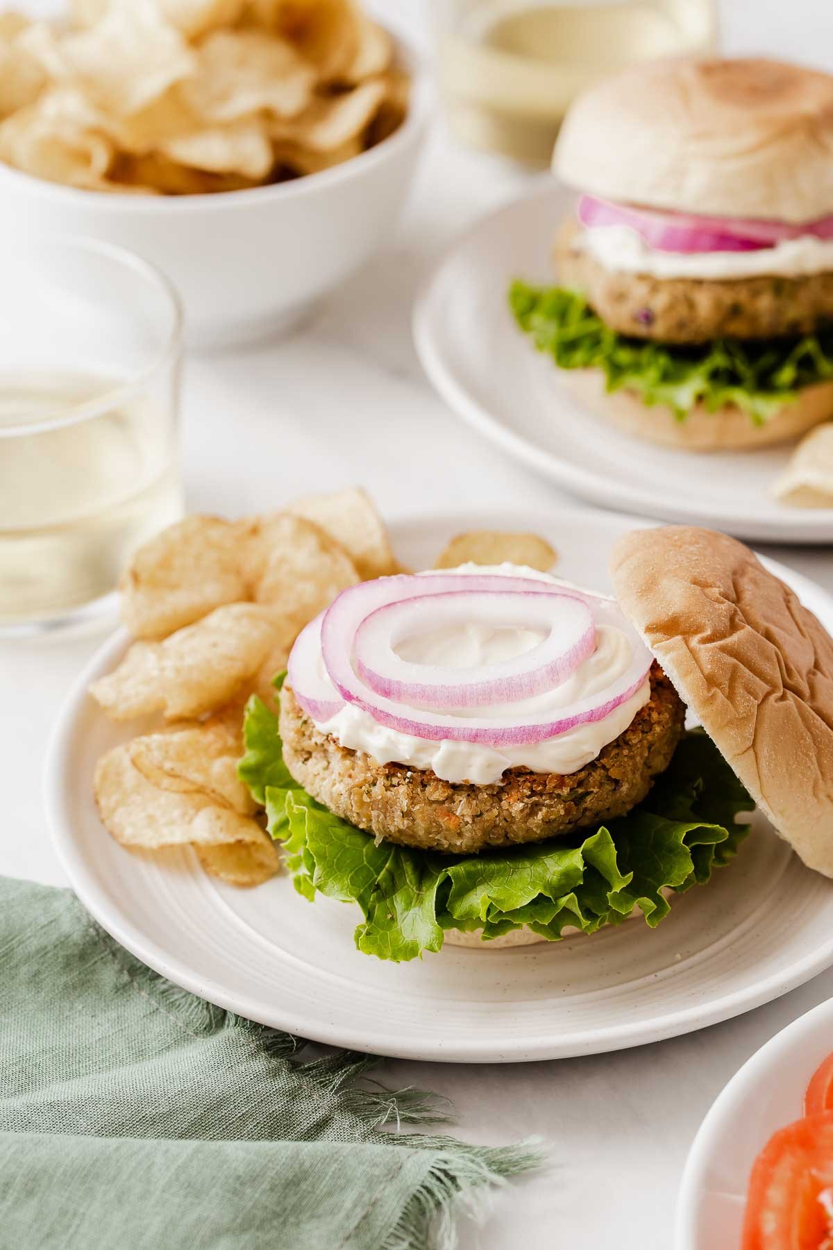 Bean burger topped with lots of mayonnaise and sliced red onion.