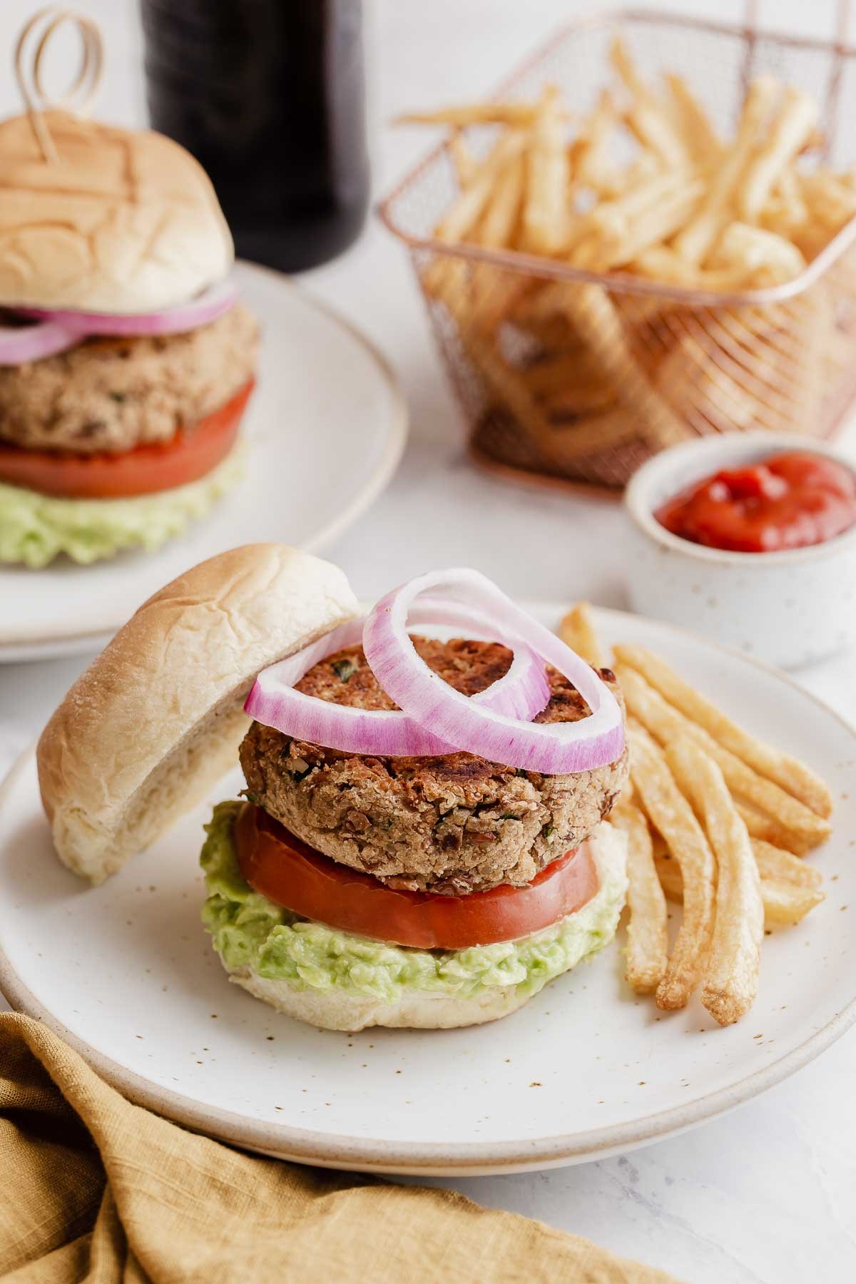 Pinto bean burgers with sliced red onions on top.