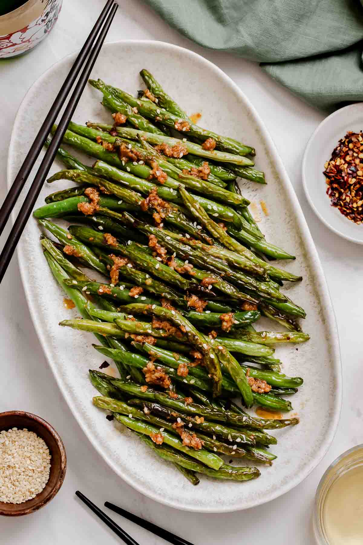Overhead shot of Asian green beans with chop sticks on side.