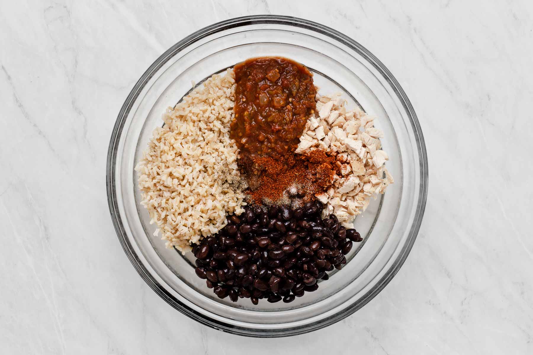 Glass bowl with rice, salsa, black beans and salsa.