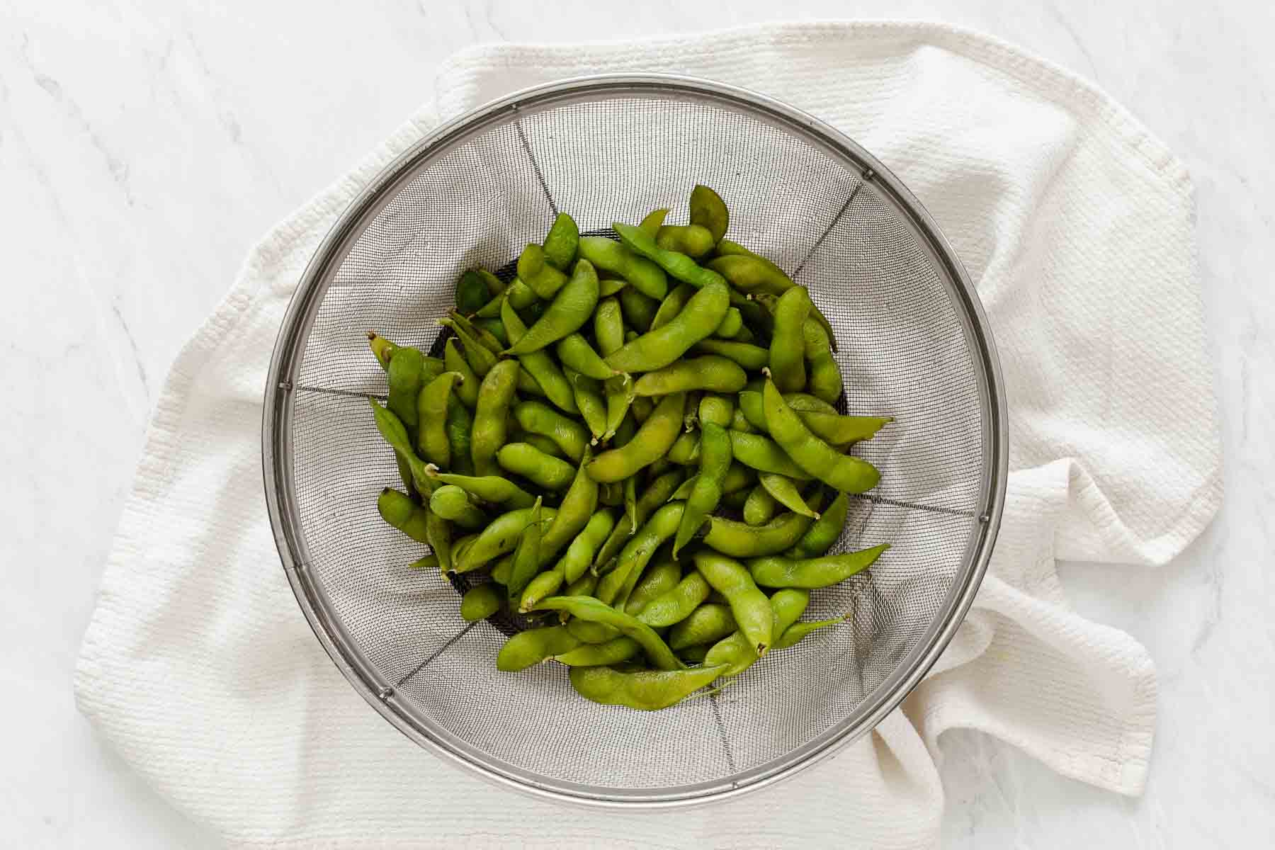 Clear bowl of freshly boiled edamame.