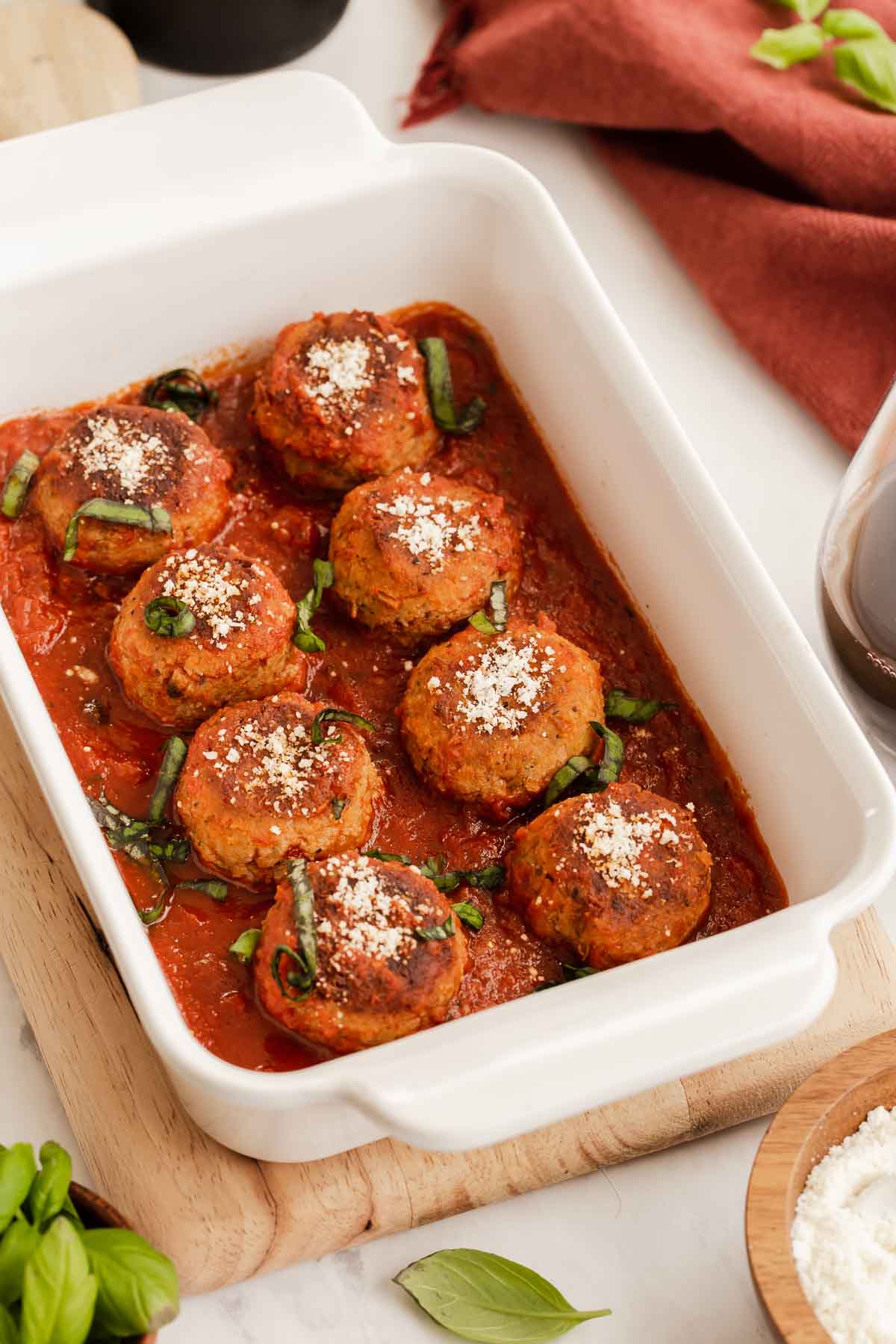 Fried lentil meatballs in a casserole dish with tomato sauce.