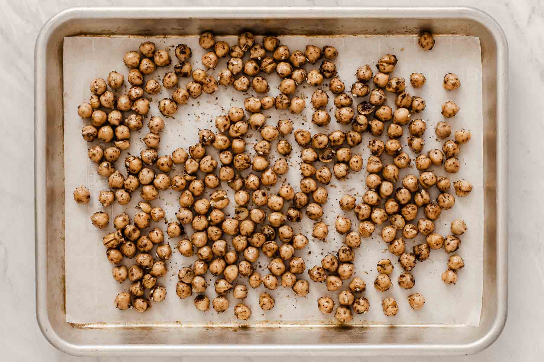 Sheet pan of chickpeas tossed in lots of dried spices.
