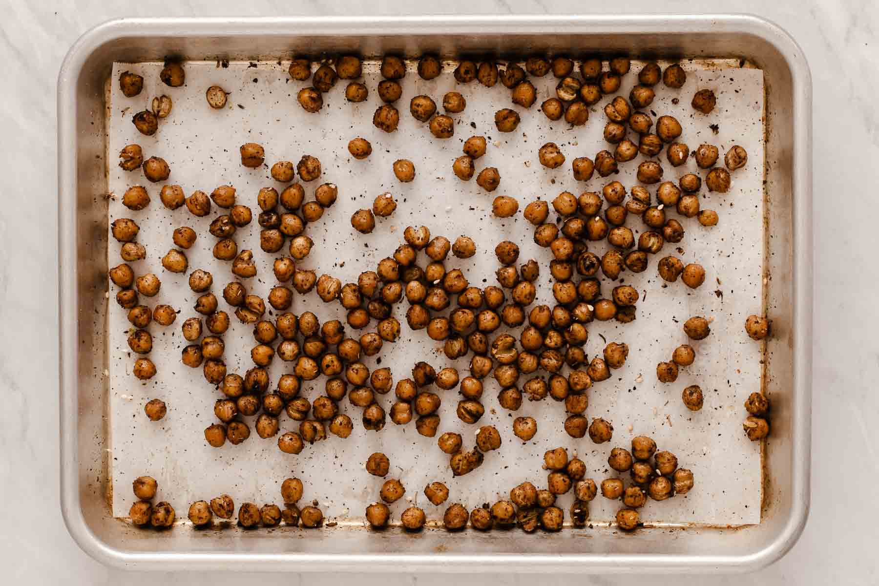 Chickpeas roasted in za'atar spice on baking sheet.
