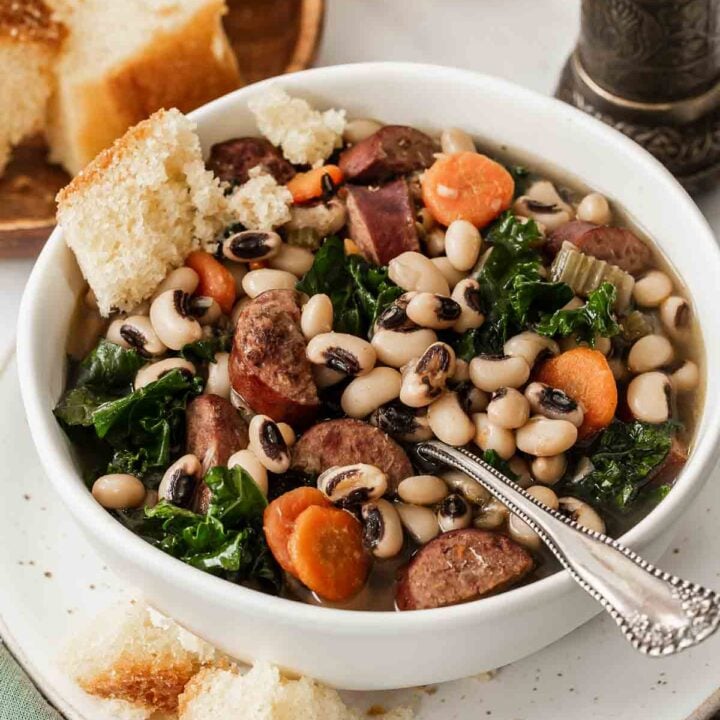 Vertical image of black eyed pea soup with carrots and greens.