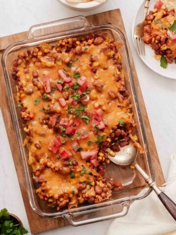 Pinto bean casserole covered in cheese in a glass 9x13 dish.