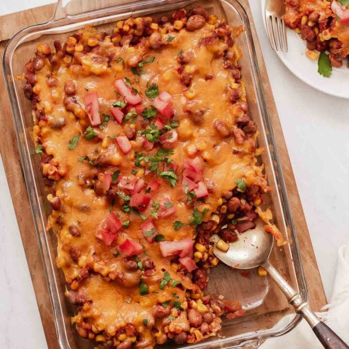 Pinto bean casserole covered in cheese in a glass 9x13 dish.