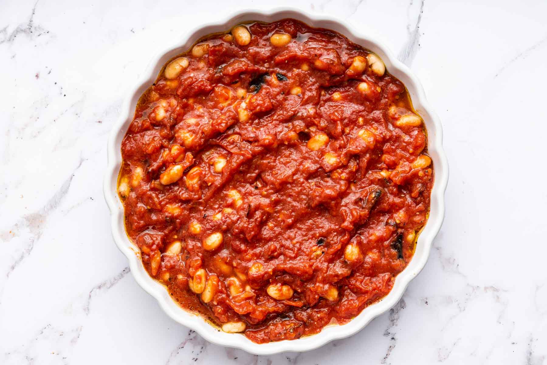 Round dish full of canned tomatoes.
